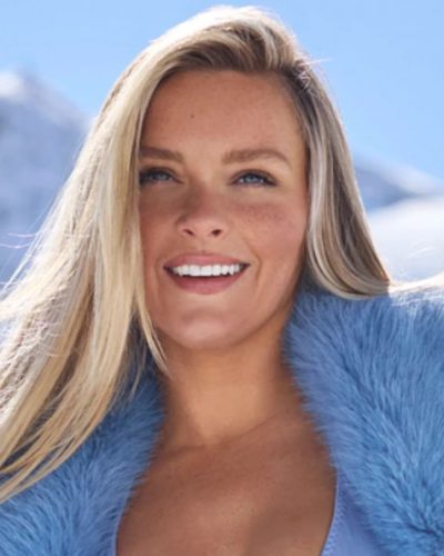 Camille Kostek wearing a light blue fur coat and red boots.