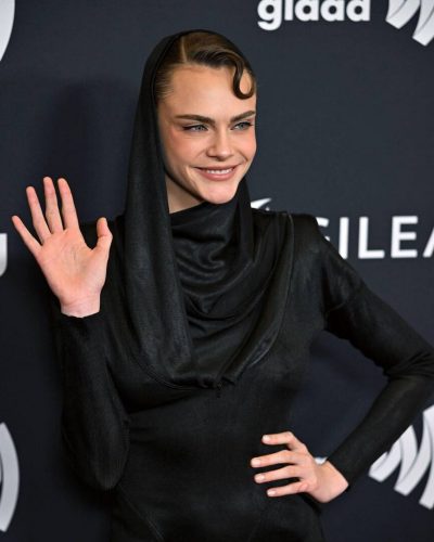 Cara Delevingne black gown contrasting against dark backdrop