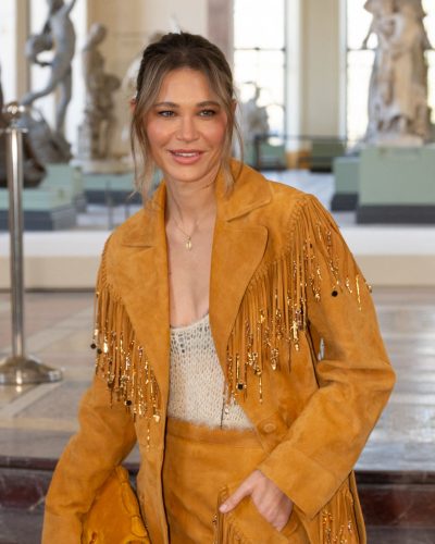 Carla Pereyra in mustard fringed coat and matching fringed skirt