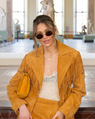 Carla Pereyra in flowy fringed skirt paired with mustard coat