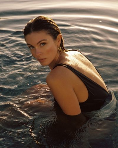 Carmella Rose in simple black swimsuit radiating summer vibes.