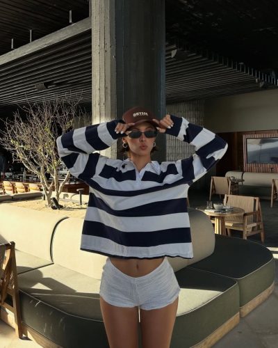 Carmella Rose in modern black swimwear surrounded by gentle ripples.