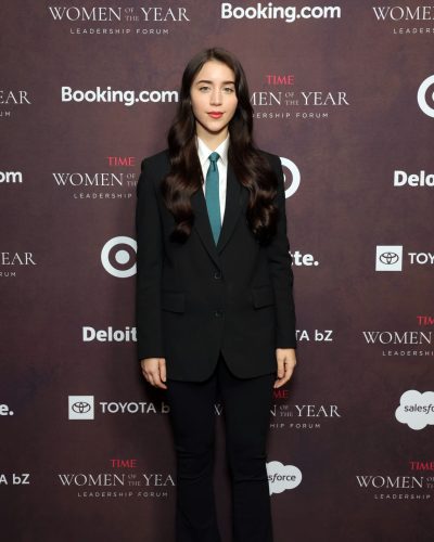 Caylee Cowan with flowing brown hair and black suit