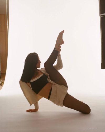 Charli D'Amelio in chic beige cardigan and black sheer tights