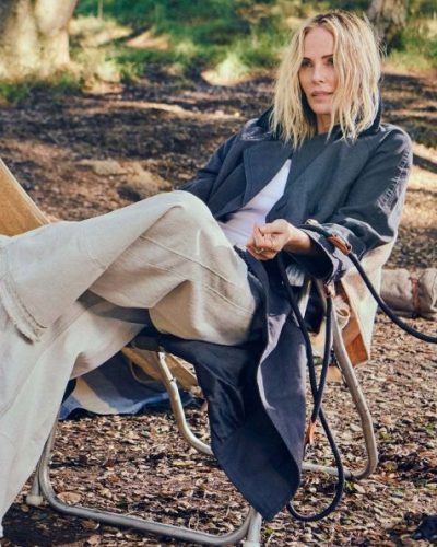 Charlize Theron in black leather biker jacket and tailored trousers.