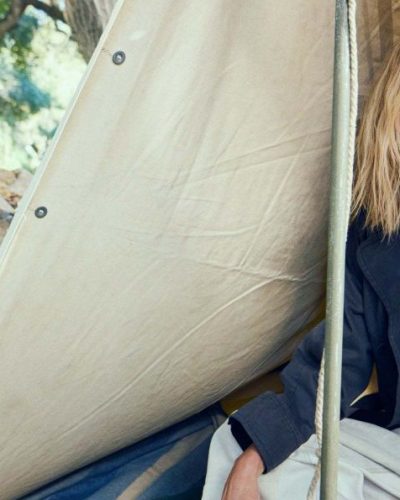 Charlize Theron in black leather jacket, white fitted tee, tailored pants.