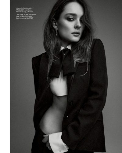 Charlotte Lawrence in black fitted pants and statement accessories.