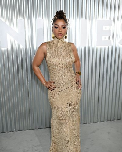 Chloe Bailey in a luxurious gold gown with a chic clutch