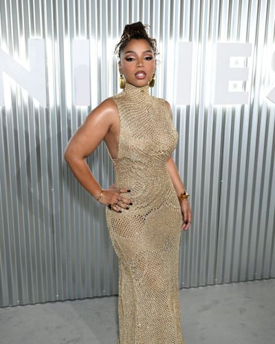 Chloe Bailey in a sophisticated gold gown with fluid fabric elements