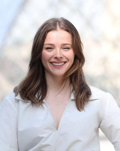 Chloe Moretz in chic white jumpsuit paired with black heels.