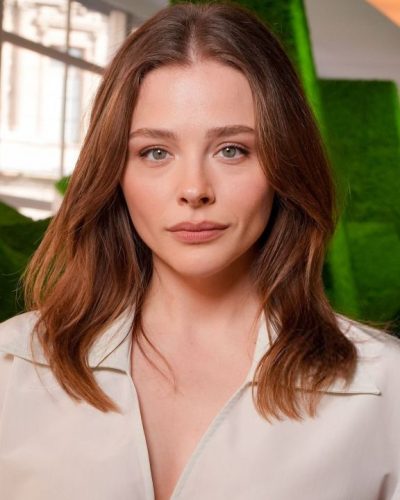 Chloe Moretz in tailored white jumpsuit with minimalist design.