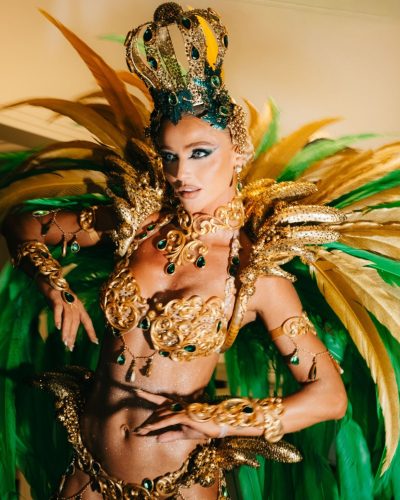Cintia Dicker in a golden embellished gown with green feathers