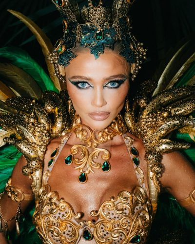 Cintia Dicker wearing a bright feathered headpiece and shimmering bodysuit