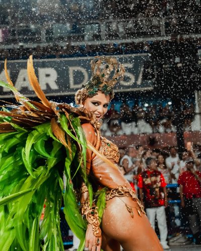 Cintia Dicker wearing a bright feathered headpiece and shimmering bodysuit