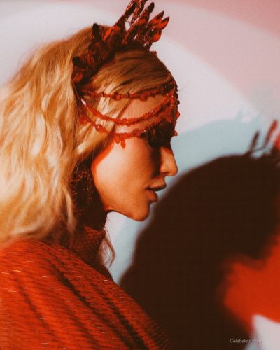 Cintia Dicker in a golden embellished gown with green feathers