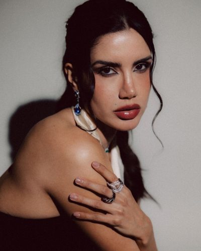 Claudia Coria in a luxurious black dress with deep neckline.