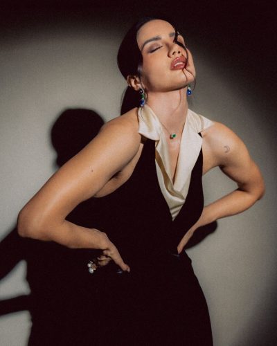 Claudia Coria styled with blue and green gemstone earrings.