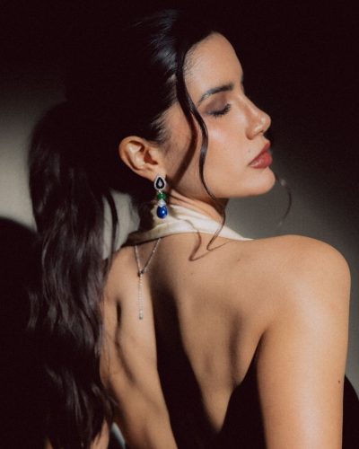 Claudia Coria in a black dress featuring a luxurious neckline.