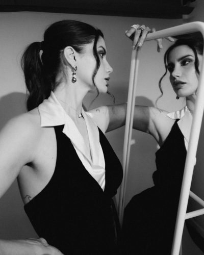 Claudia Coria wearing a sophisticated black gown with collar.