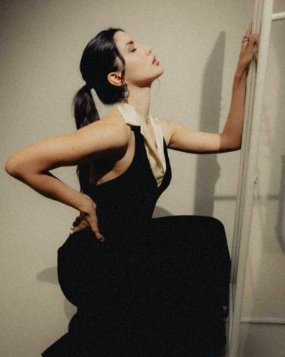 Claudia Coria in a sleek black dress with shimmering details.