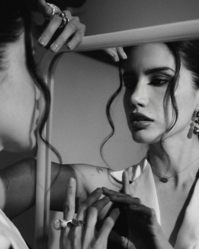 Claudia Coria wearing a fitted black gown with silk accents.