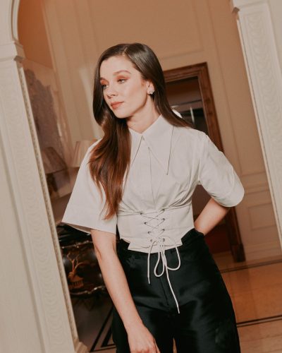Claudia Jessie in light gray top and black satin trousers.