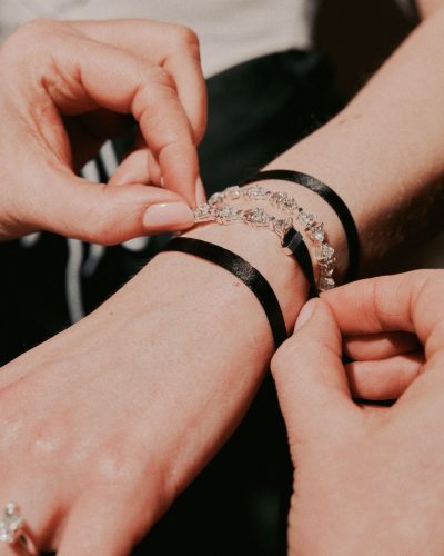 Claudia Jessie wearing chic black satin trousers and lace-up top.