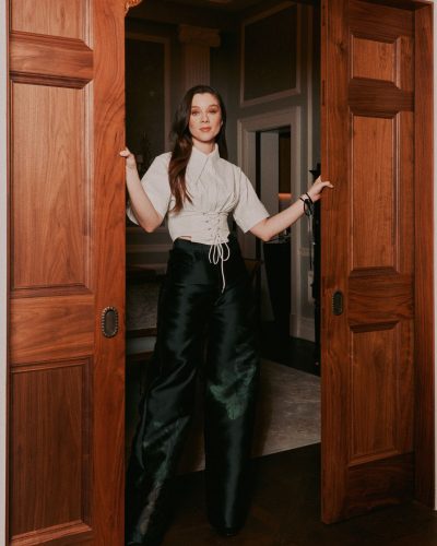 Claudia Jessie in fashionable gray top with chic black satin pants.