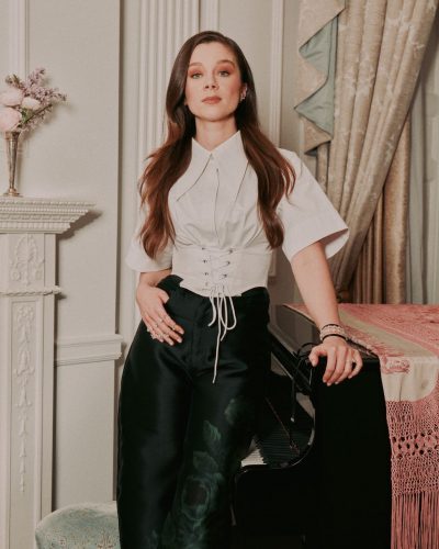 Claudia Jessie in sophisticated black satin trousers and gray top.