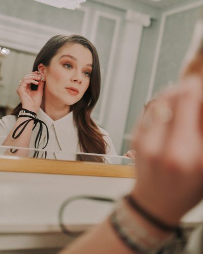 Claudia Jessie in modern light gray top complemented by black pants.