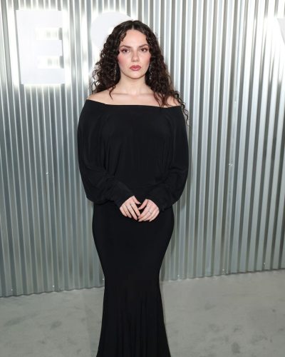 Dafne Keen wearing black gown with soft makeup and curly hair