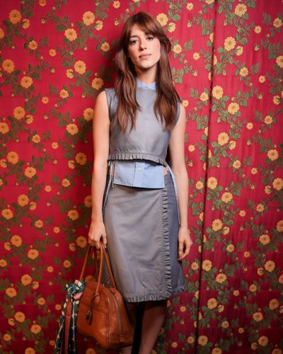 Daisy Edgar-Jones wearing a tailored gray dress with ruffles.