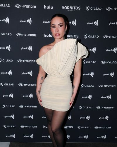 Demi Lovato fashionable cream gown complemented by glossy black heels