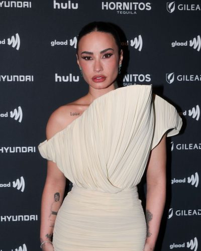 Demi Lovato elegant cream gown featuring contemporary off-the-shoulder design