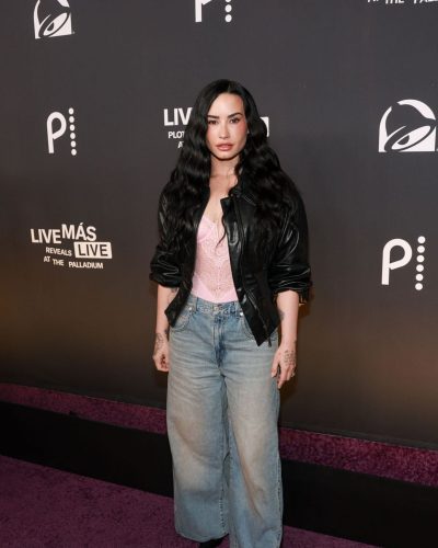 Demi Lovato lace bodysuit peeking through cropped black leather jacket.