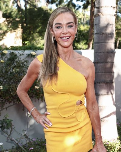 Denise Richards wearing a stylish one-shoulder yellow gown