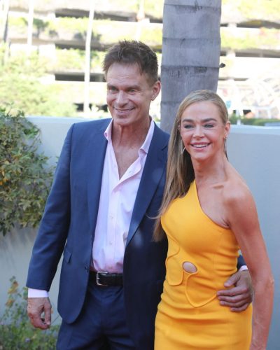 Denise Richards in a bold yellow dress complemented by turquoise accessories