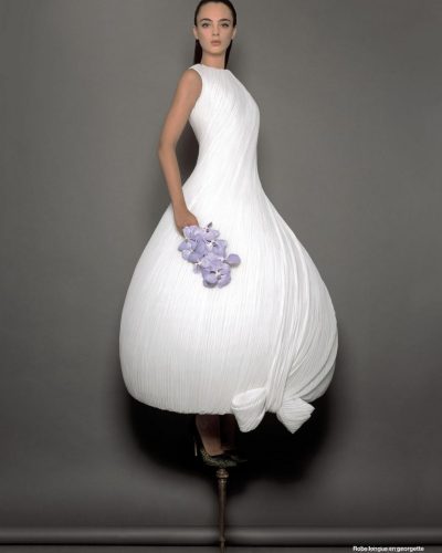 Deva Cassel wearing a white dress with intricate design details.