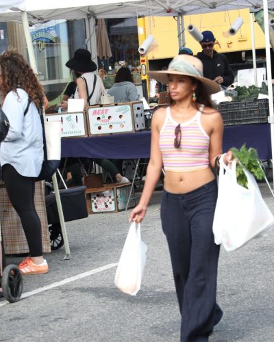 Diane Guerrero with brown wooden sandals and vibrant crop top.