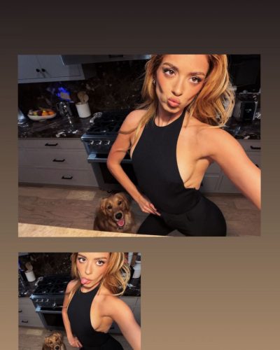 Dixie D'Amelio black jumpsuit with playful expression and phone