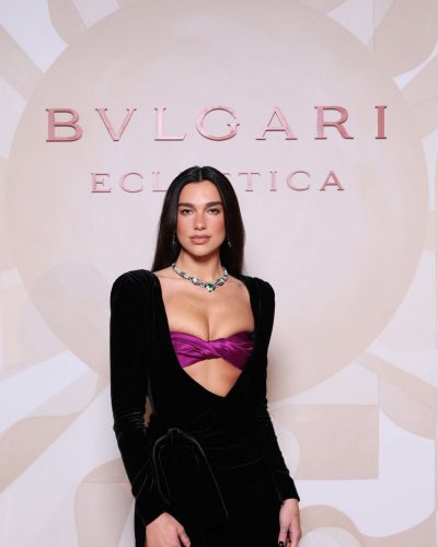 Dua Lipa dramatic black dress with purple accent at the bust