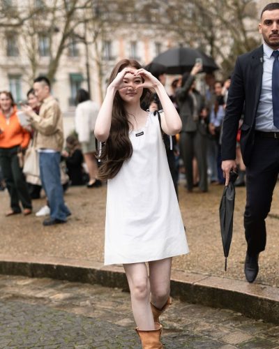 Ella Gross fashion-forward in white dress and knee-high boots.