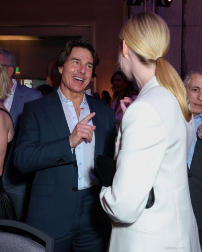 Elle Fanning in a sleek black top under white blazer