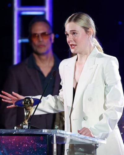 Elle Fanning wearing a white suit and matching trousers