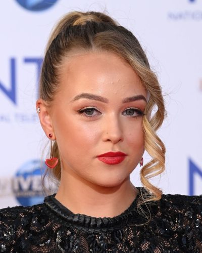 Ellie Dadd in fitted black jumpsuit with contrasting red nails.