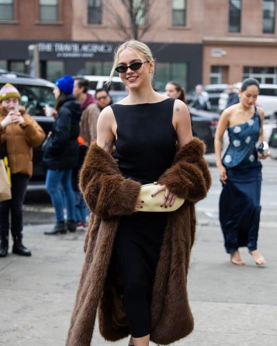 Emma Brooks black dress and brown fur outerwear