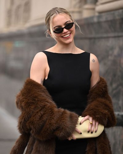 Emma Brooks fitted black dress accessorized with yellow clutch