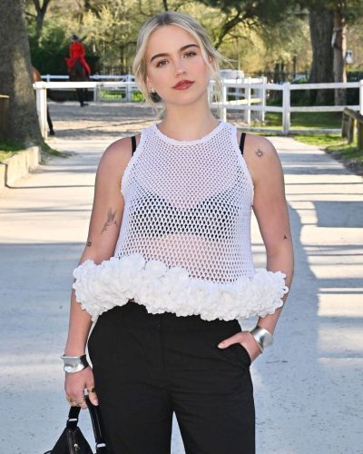 Emma Brooks black high-waisted trousers paired with white mesh top
