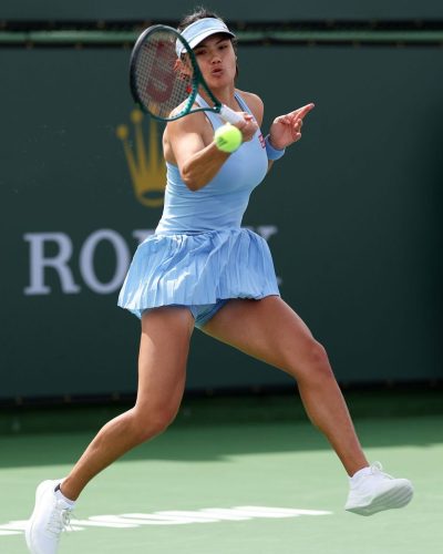 Emma Raducanu classic white tennis shoes and pleated skirt