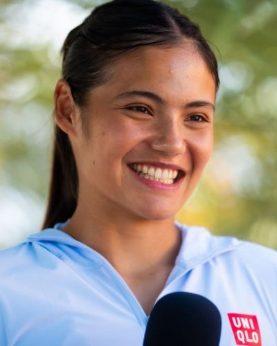 Emma Raducanu wearing casual blue hoodie and engaging with media